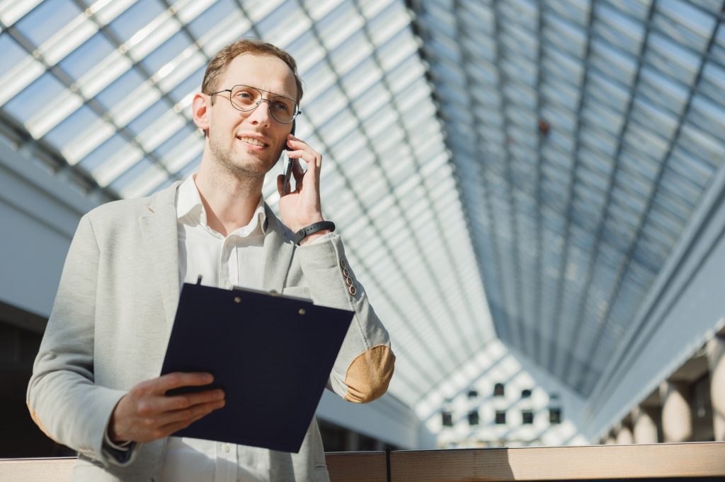 Man with folder makes survey on mobile, an anonymous survey, cold calls, business proposal, sales